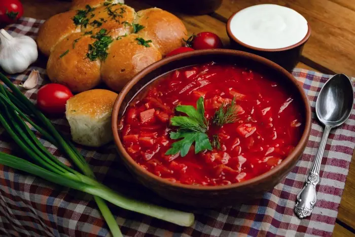 Красива миска борщу з хлібом та свіжими овочами