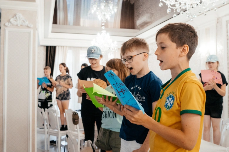 Діти співають та тримають картки під час святкування Святого Миколая