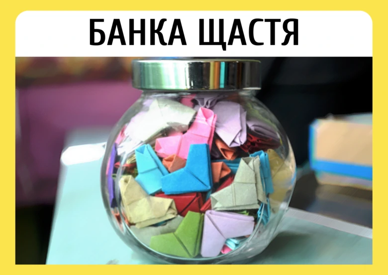 Скляна банка з кольоровими паперовими серцями для святкування щастя