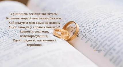 Книга з двома обручними кільцями та привітанням до річниці весілля.