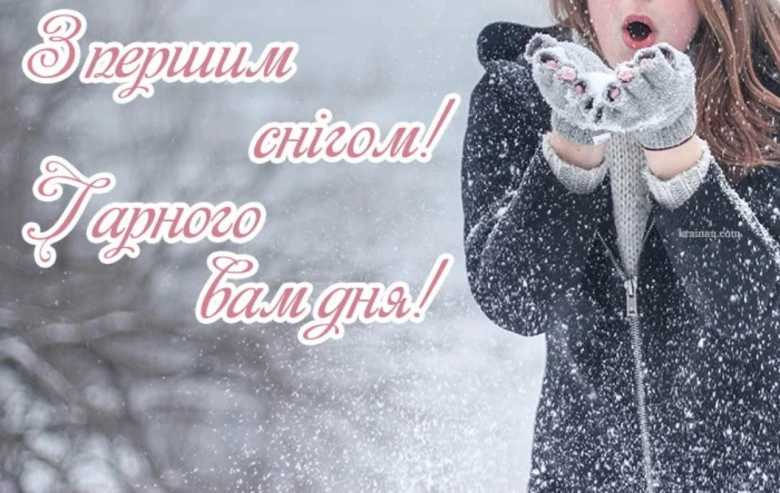Дівчина дме снігом на фоні першого снігопаду.